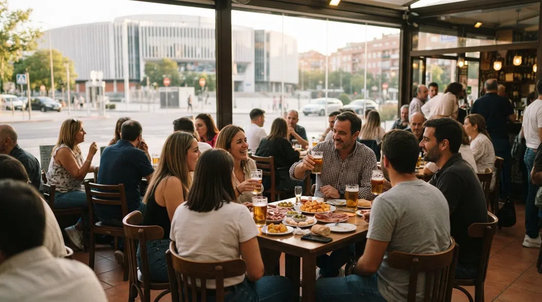 la terraza acristalada de Cervecería Ecu frente al Palacio de Deportes, llena de locales con cervezas y tapas gratis enormes en la luz de la tarde